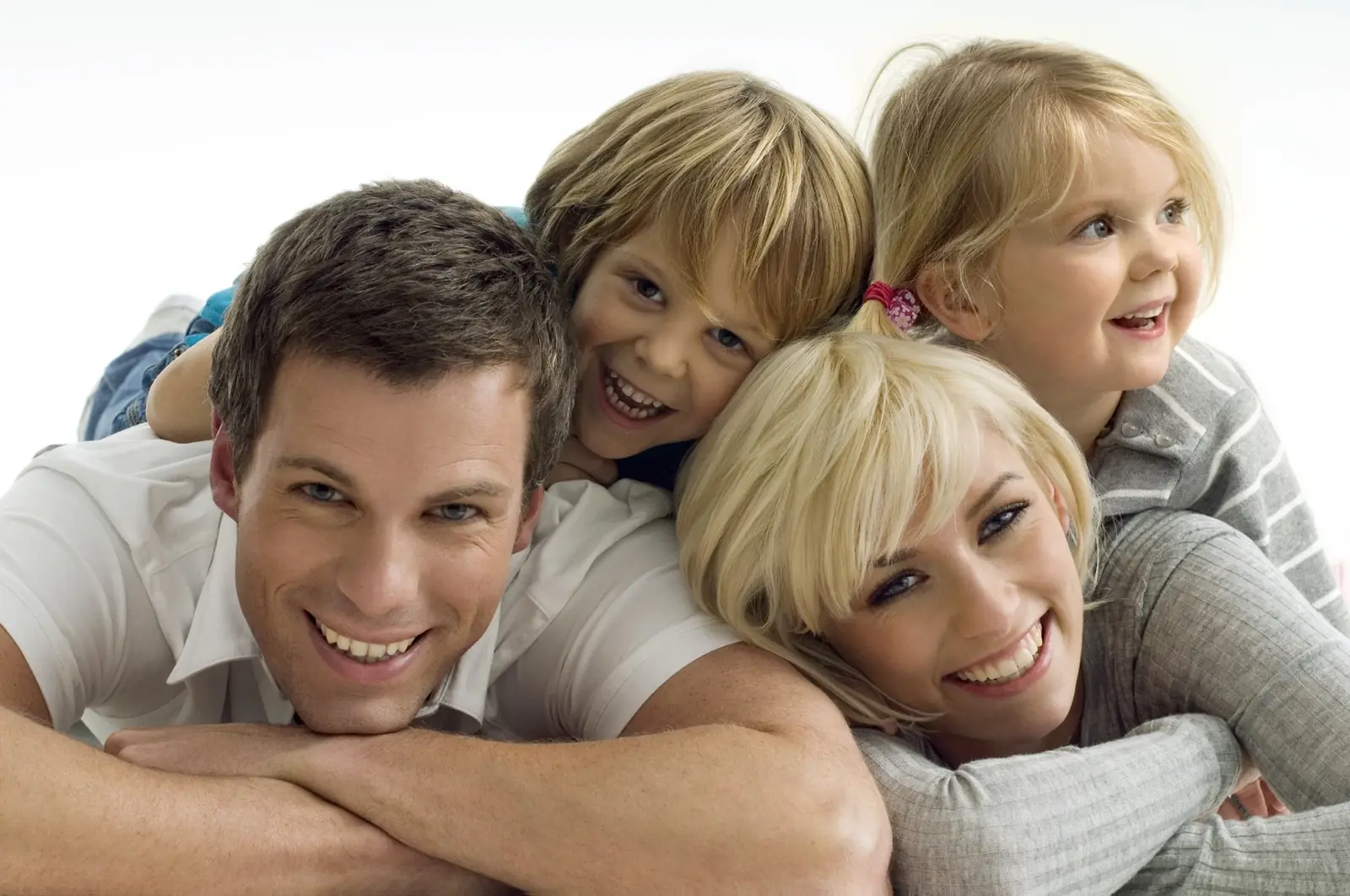 A smiling family of four, two parents and two young children