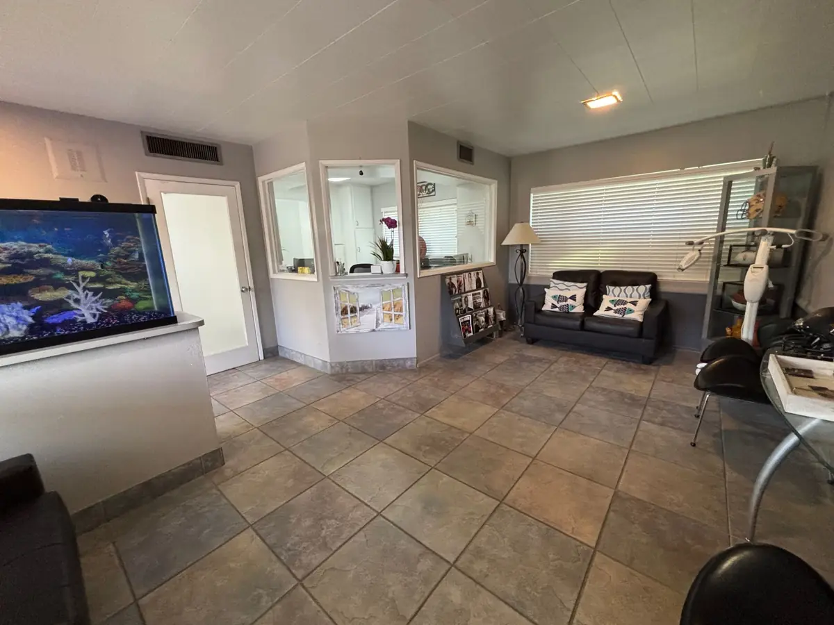 The waiting room at Ahn & Perez DDS, with an aquarium, a sofa and the front desk windows